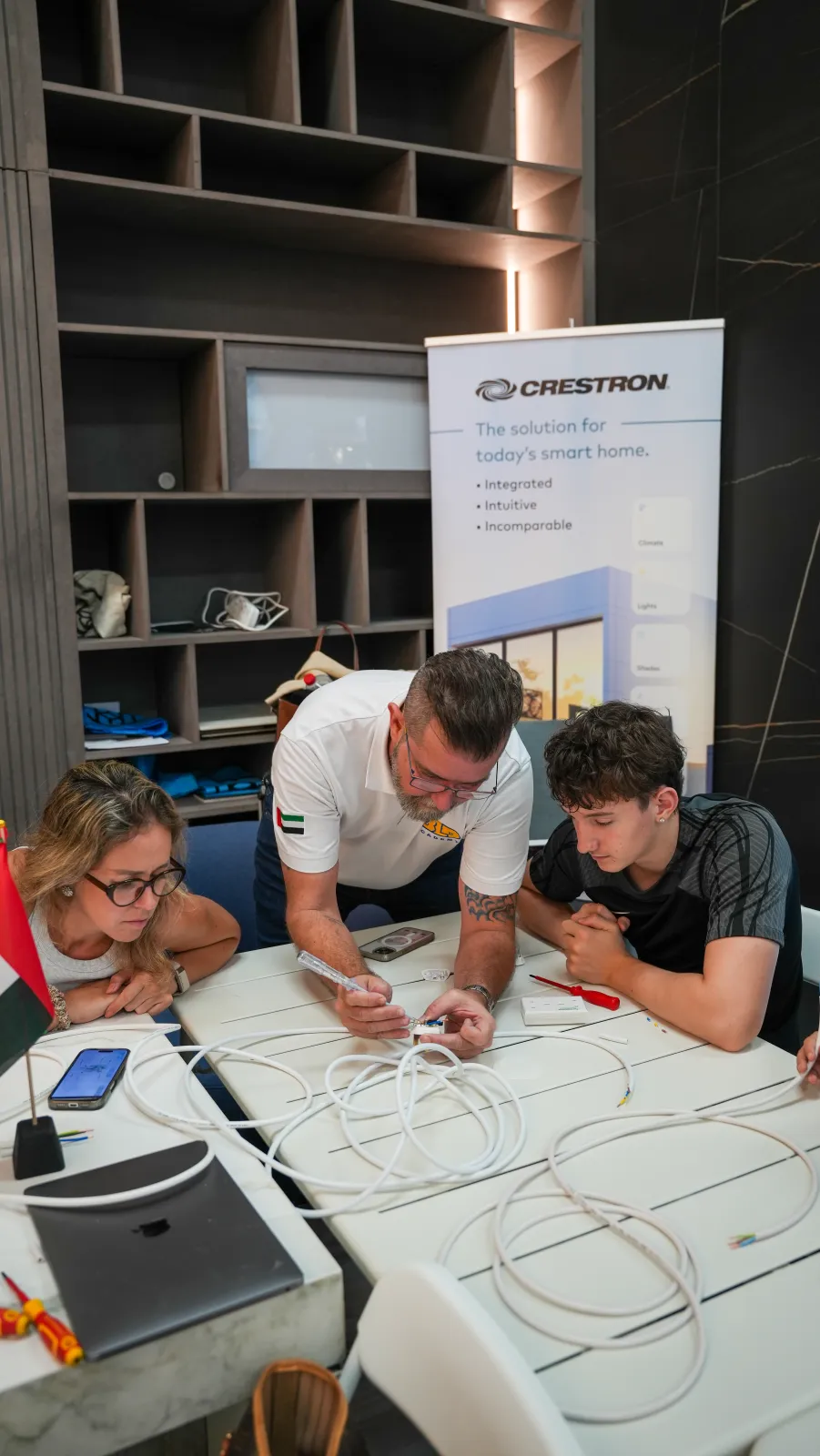 A BLD Academy trainer guiding adults through home wiring at a DIY workshop in Dubai
